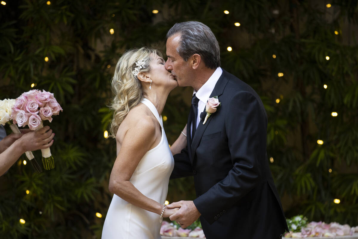 Sheila Daley, left, and James Dunbar, share a kiss during their wedding ceremony at the Wynn ho ...