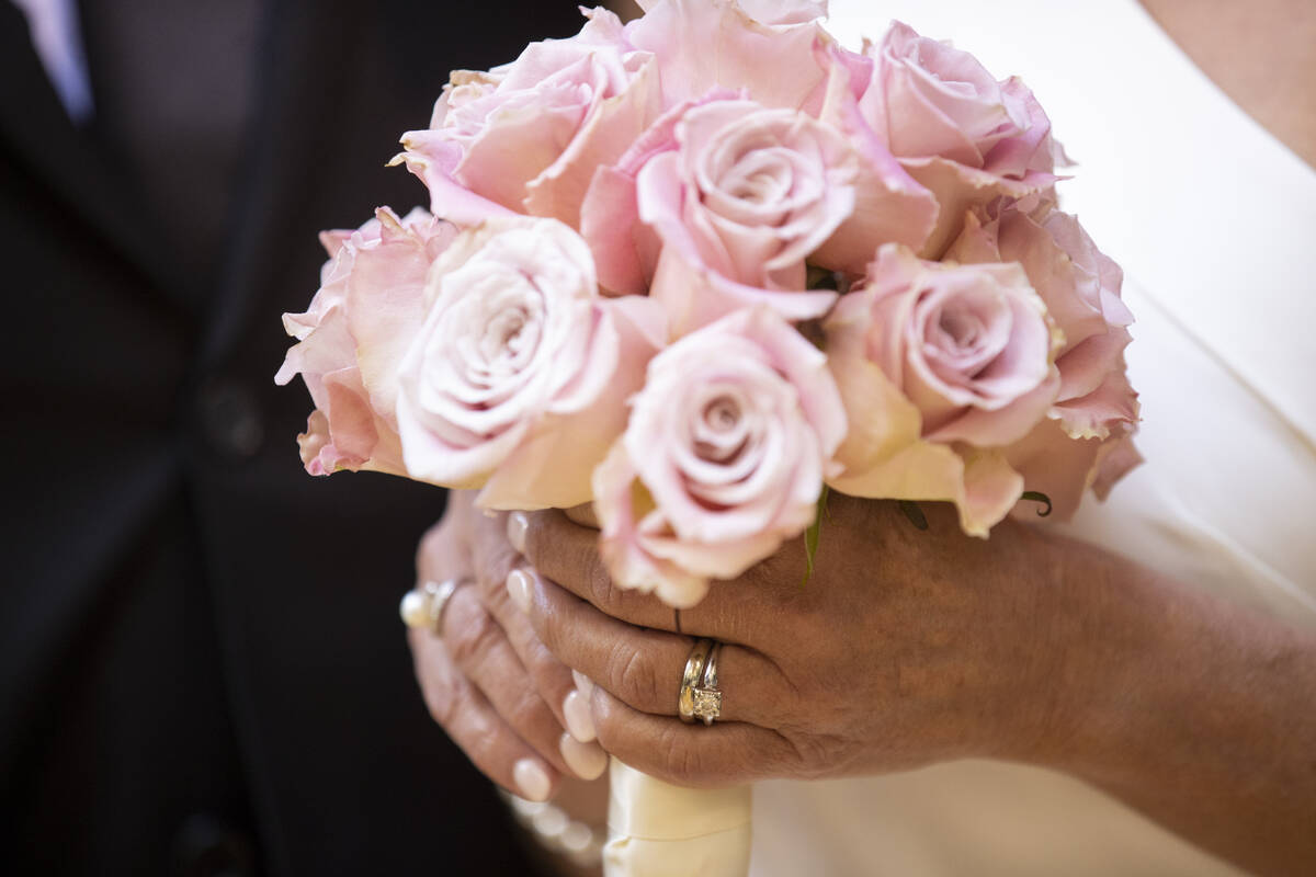 Sheila Daley holds a bouquet of roses following her wedding ceremony with her husband James Dun ...