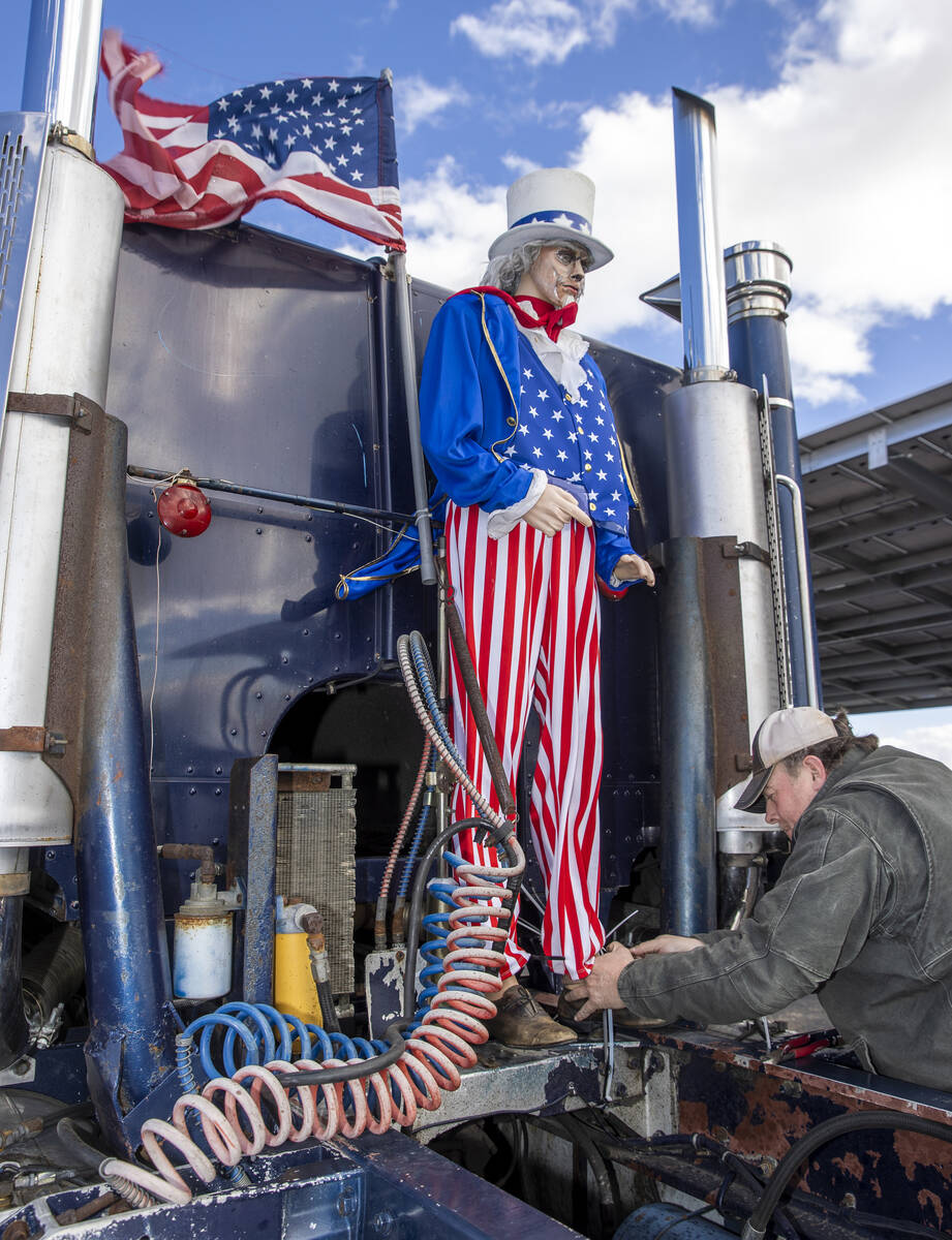 Truck driver Fred with Bouie River Trucking of Hattiesburg, Mississippi, attaches an Uncle Sam ...