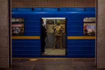 A Ukrainian army officer looks at his phone in a local train in Kyiv, Ukraine, Wednesday, Feb. ...