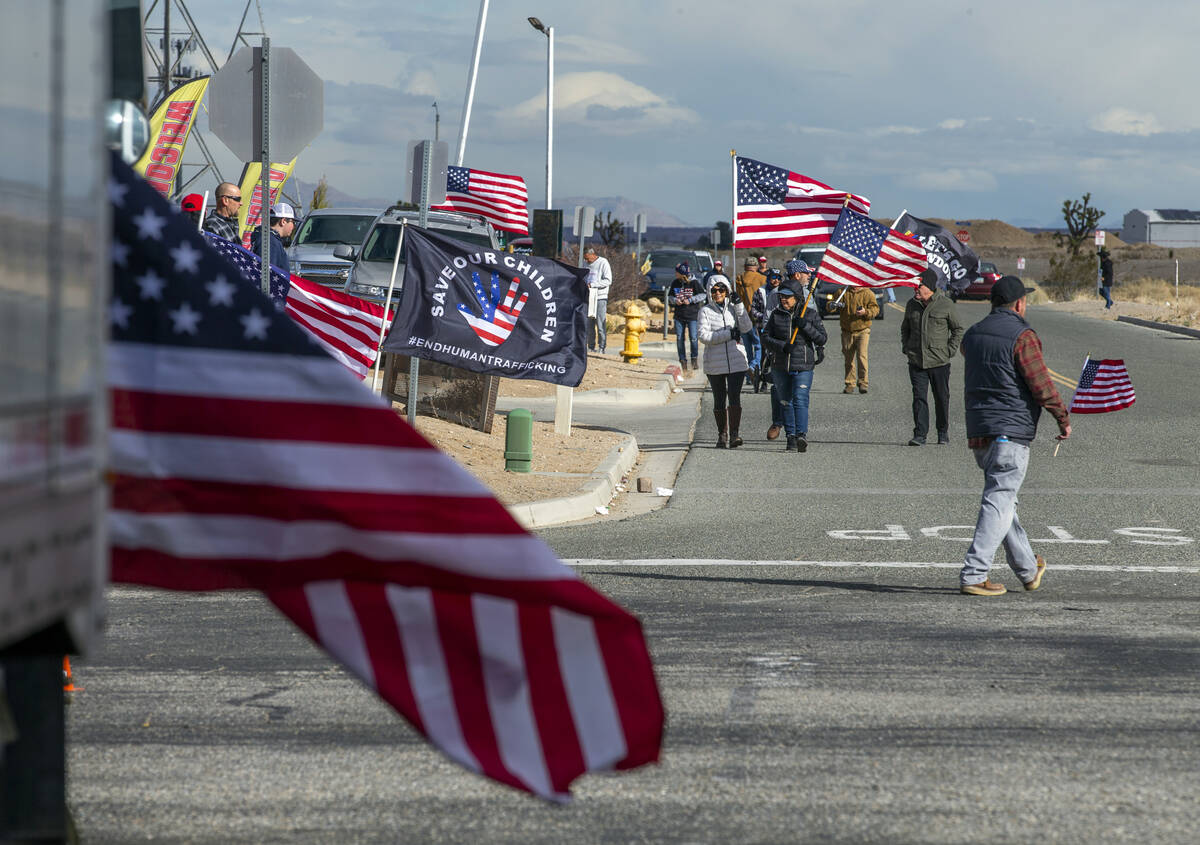 Attendees carry flags while arriving for a departure event for The People’s Convoy at Ad ...