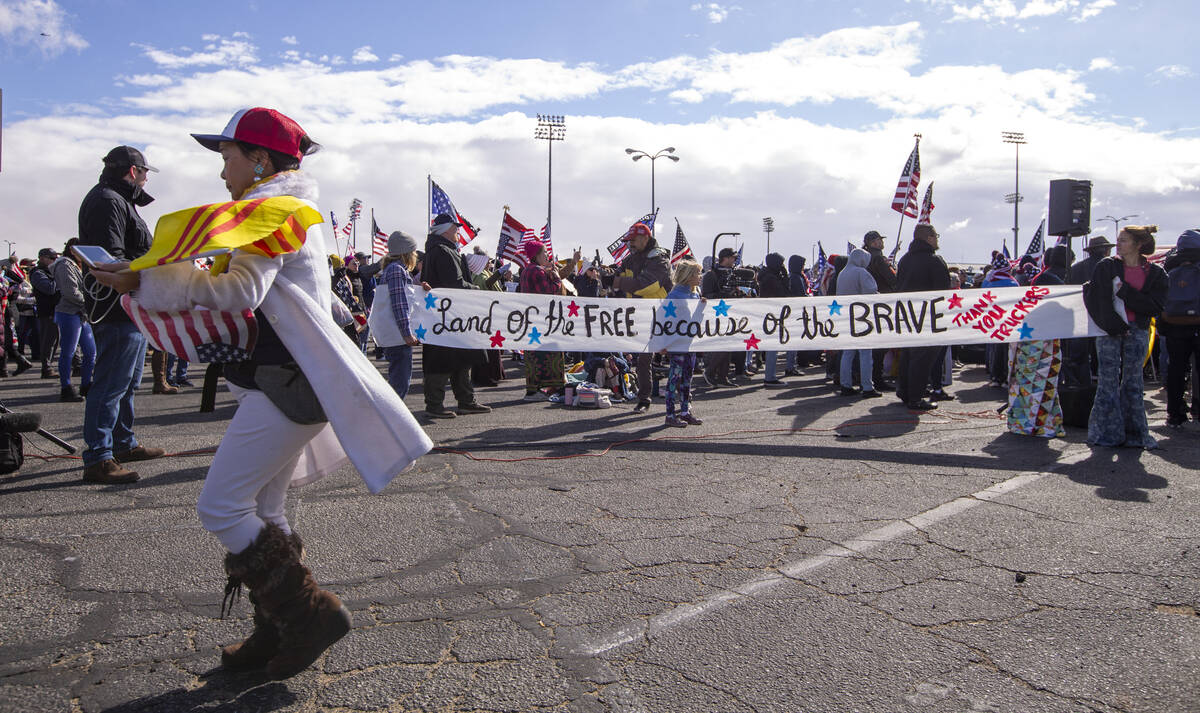 Attendees hold a long sign during a departure event for The People’s Convoy at Adelanto ...