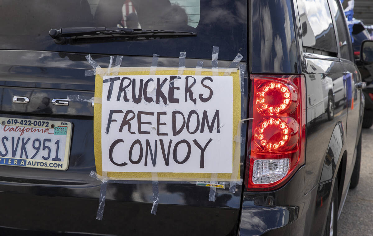 Signs on the rear of a vehicle during a departure event for The People’s Convoy at Adela ...