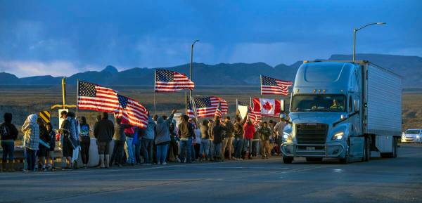 Supporters line an I-40 overpass at sunset in Arizona nearly 20 miles out of Kingman awaiting T ...