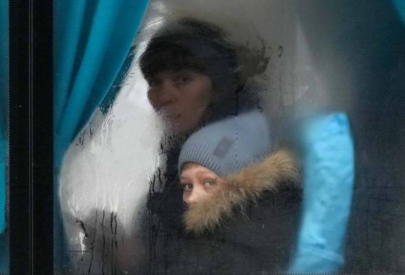 A woman and child peer out of the window of a bus as they leave Sievierodonetsk, the Luhansk re ...