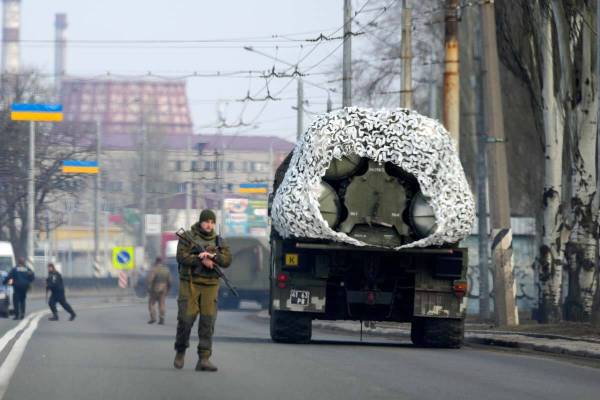 A Ukrainian soldier stands next to a military vehicle on a road in Kramatosrk, eastern Ukraine, ...
