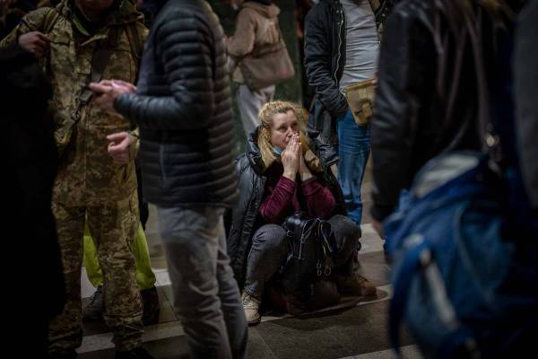 A woman reacts as she waits for a train trying to leave Kyiv, Ukraine, Thursday, Feb. 24, 2022. ...