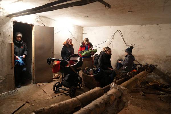 People gather in a shelter during Russian shelling, in Mariupol, Ukraine, Thursday, Feb. 24, 20 ...