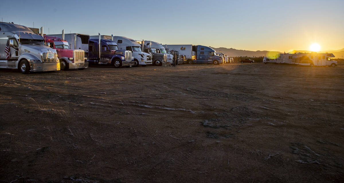 Truckers parked in a back lot for The People’s Convoy parked for the night greet the sun ...