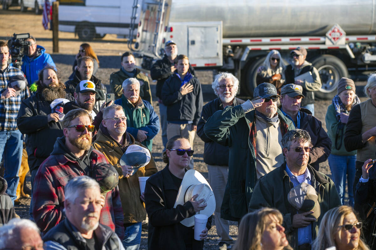 Truckers listen to the National Anthem as they participate in a morning meeting to discuss the ...