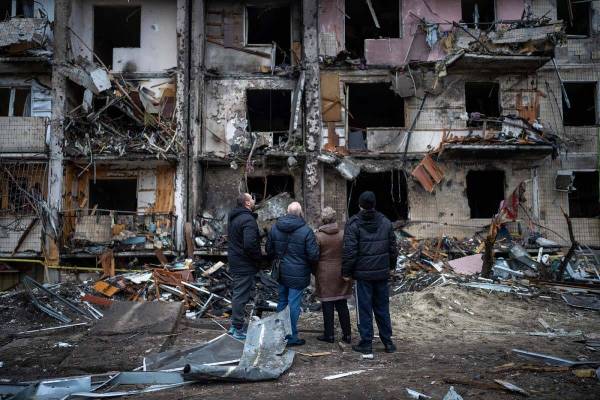 People look at the damage following a rocket attack the city of Kyiv, Ukraine, Friday, Feb. 25, ...