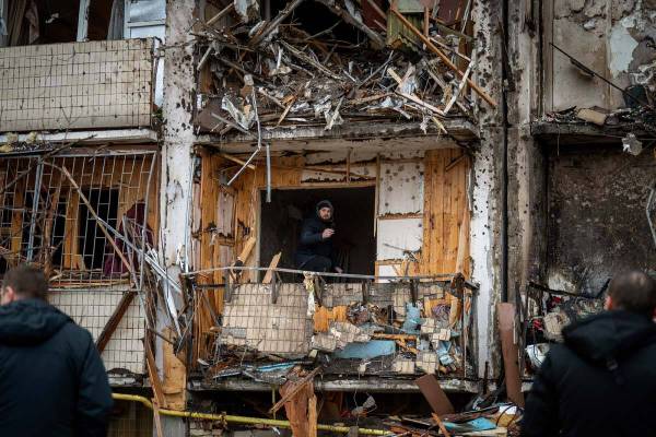 A man inspects the damage at a building following a rocket attack on the city of Kyiv, Ukraine, ...