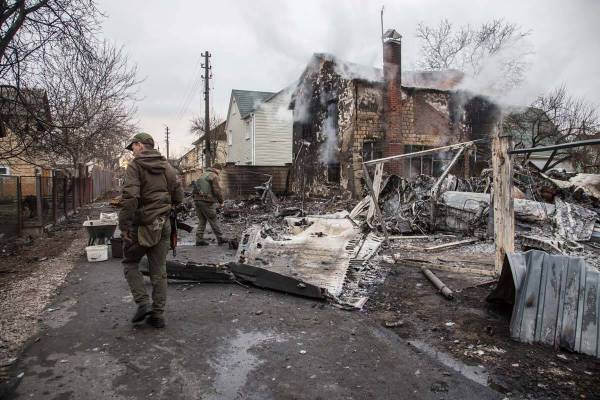 Ukrainian servicemen walk at fragments of a downed aircraft seen in in Kyiv, Ukraine, Friday, F ...