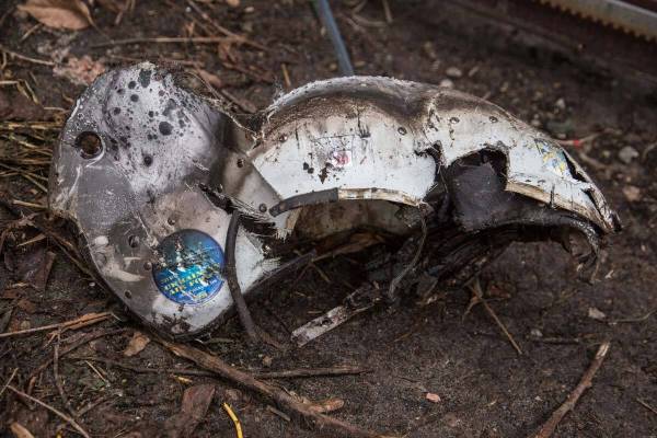 A military pilot helmet next to fragments of a downed aircraft is seen in in Kyiv, Ukraine, Fri ...