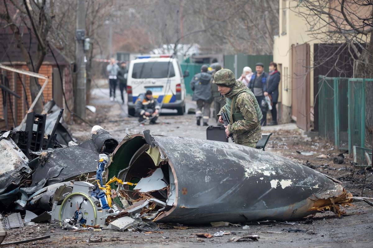 A Ukrainian Army soldier inspects fragments of a downed aircraft in Kyiv, Ukraine, Friday, Feb. ...