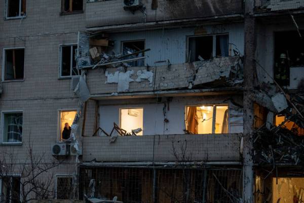 A man inspects the damage at a building following a rocket attack on the city of Kyiv, Ukraine, ...