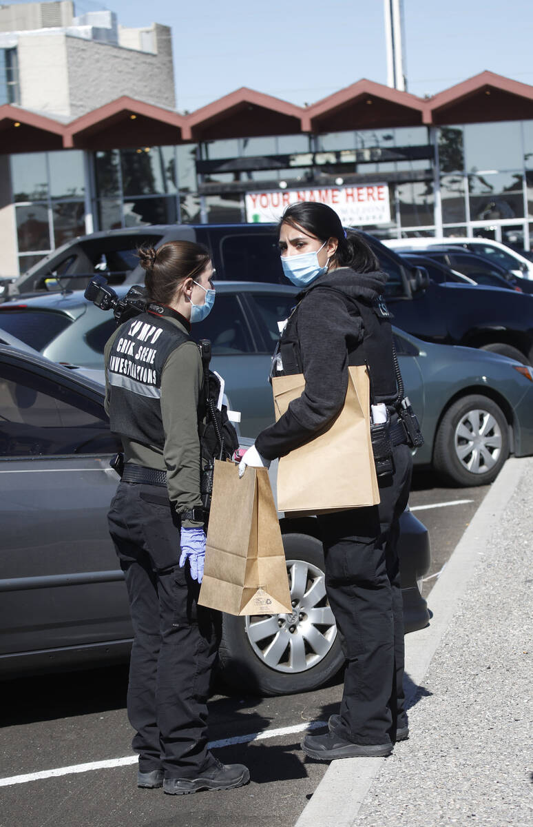 Police officers carry brown bags during investigating at Manny's Glow Ultra Lounge & Restauran ...