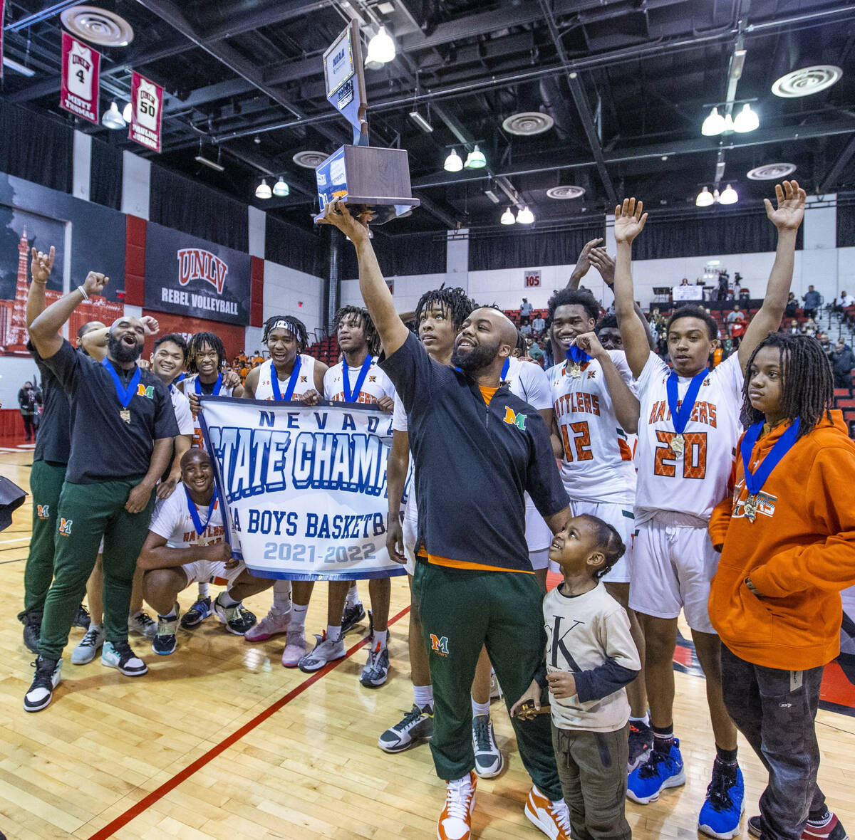 Mojave head coach KeJuan Clark holds the winning trophy as he and players celebrate their win o ...