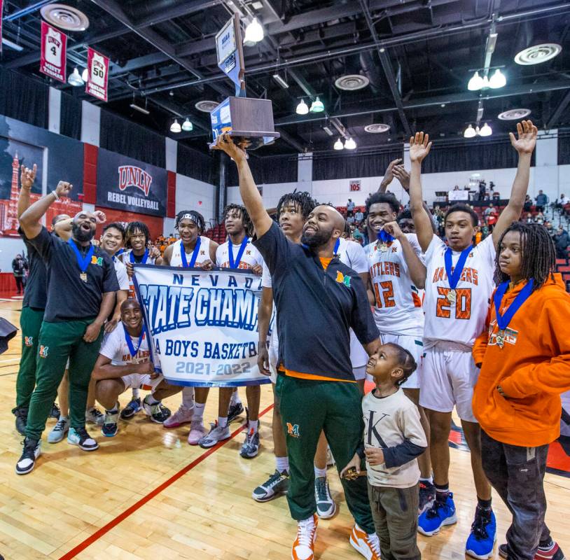 Mojave head coach KeJuan Clark holds the winning trophy as he and players celebrate their win o ...