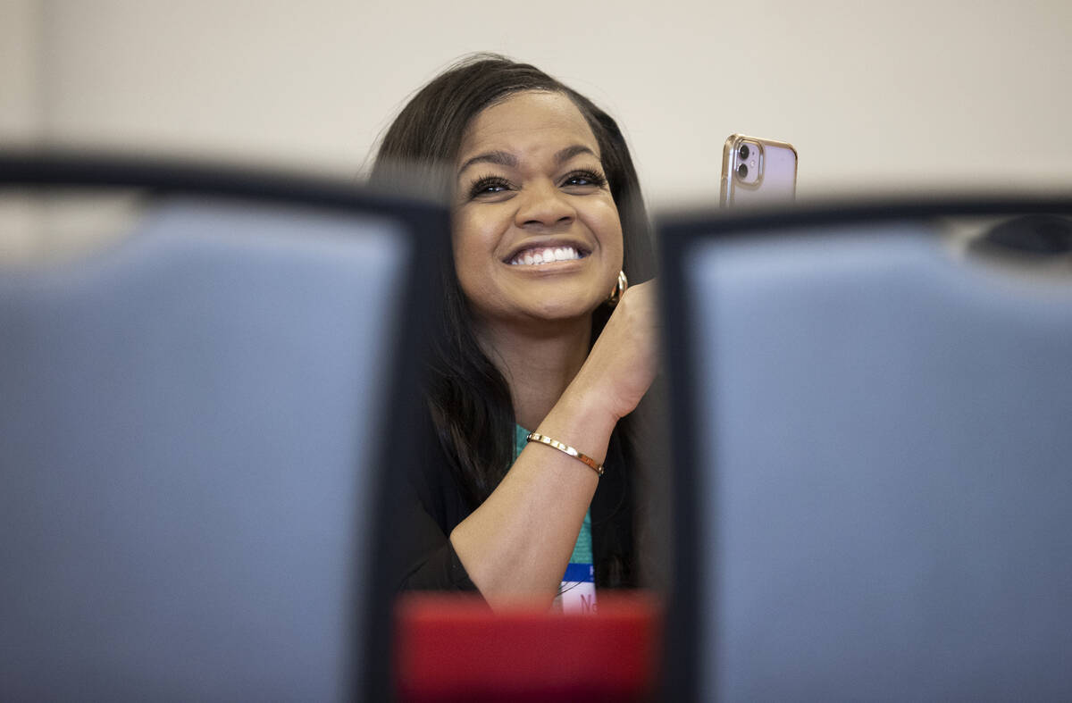 Nachelle Milam reacts to a speaker while using her phone during an exercise at a leadership su ...