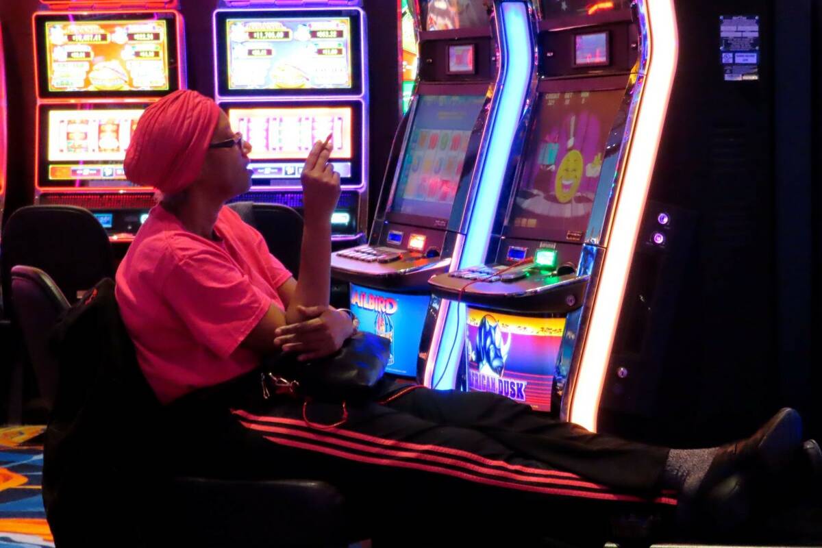 A gambler smoking while playing a slot machine at the Ocean Casino Resort in Atlantic City N.J. ...