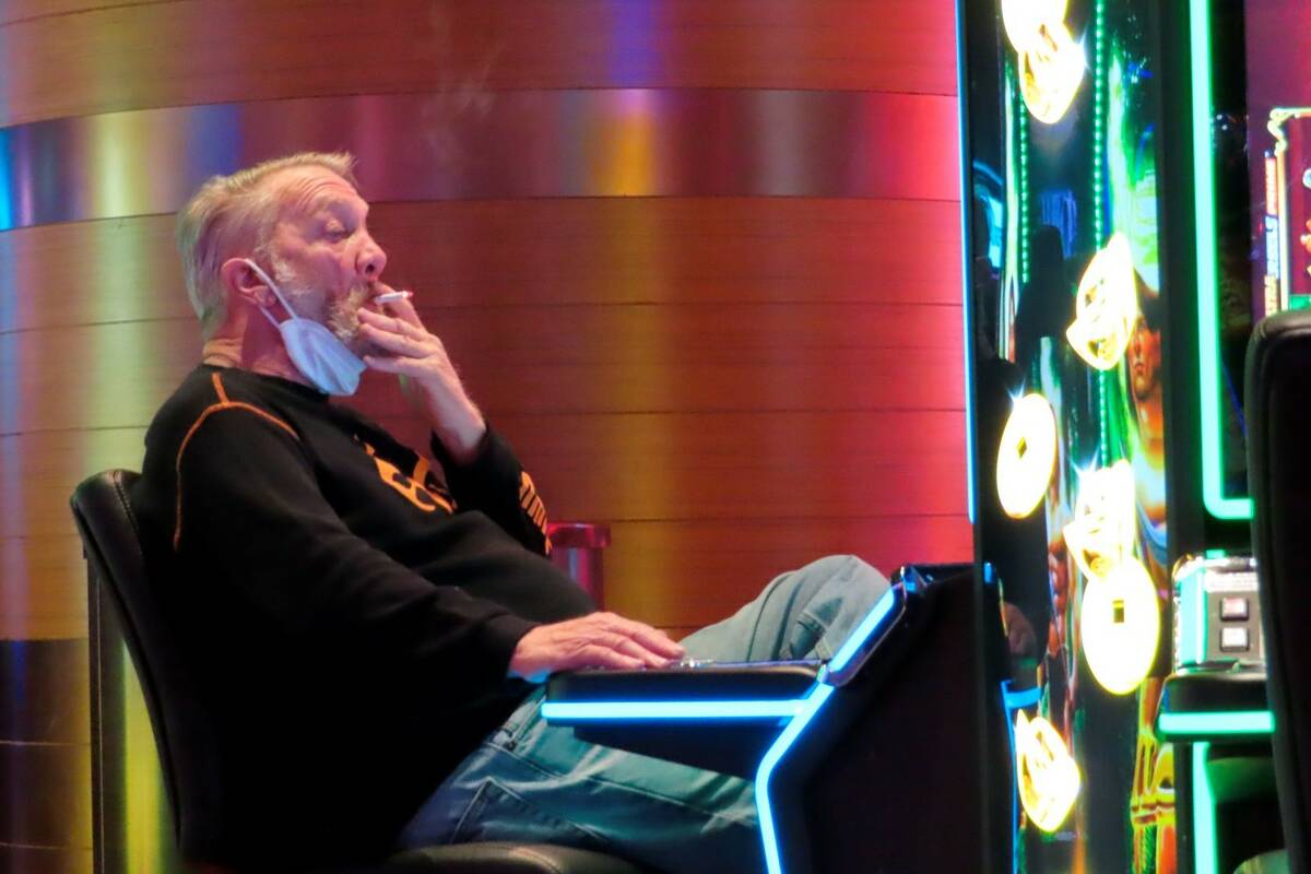 A gambler smoking while playing a slot machine at the Ocean Casino Resort in Atlantic City N.J. ...