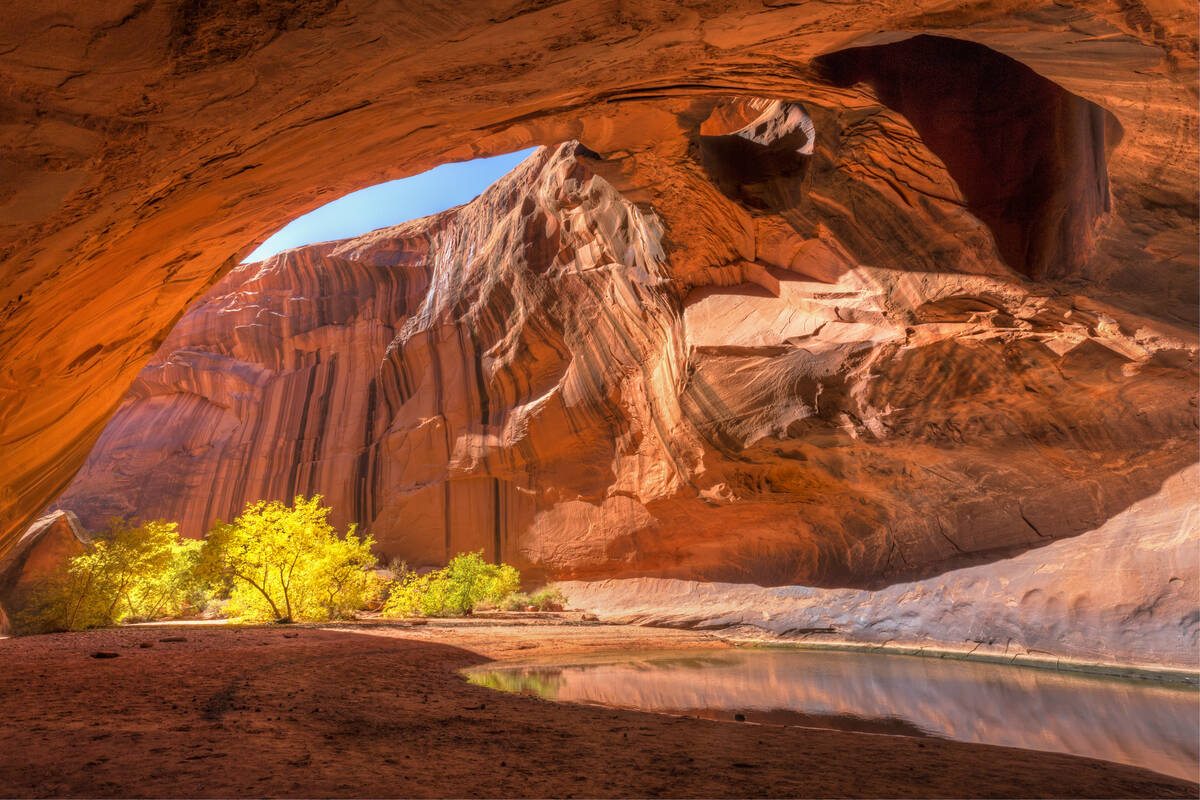 The red sandstone domed ceiling of Golden Cathedral in Neon Canyon has two arch potholes, with ...