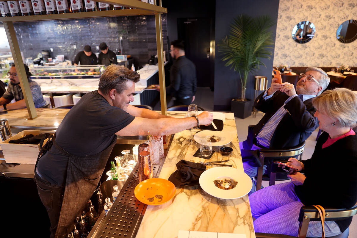 Celebrity Chef Todd English shaves truffles for John and Alexandra Curtis at the opening of his ...