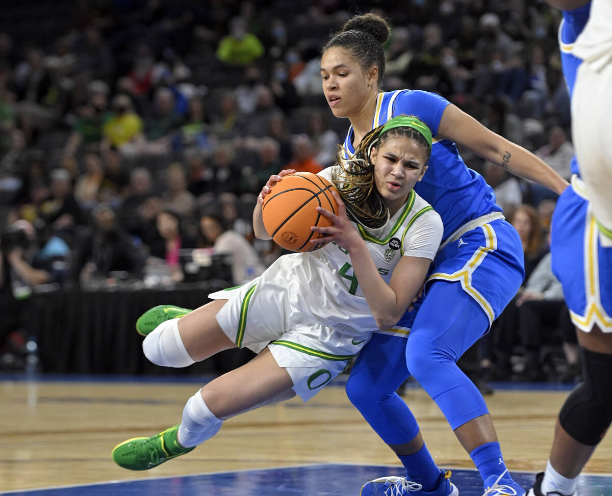 Oregon guard Endyia Rogers (4) is fouled as she drives to the basket against UCLA guard Jaelynn ...