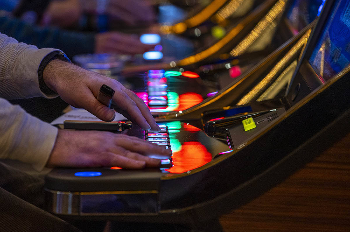 A guest plays a slot machine with others nearby at Red Rock Casino on Tuesday, Dec. 26, 2021, i ...