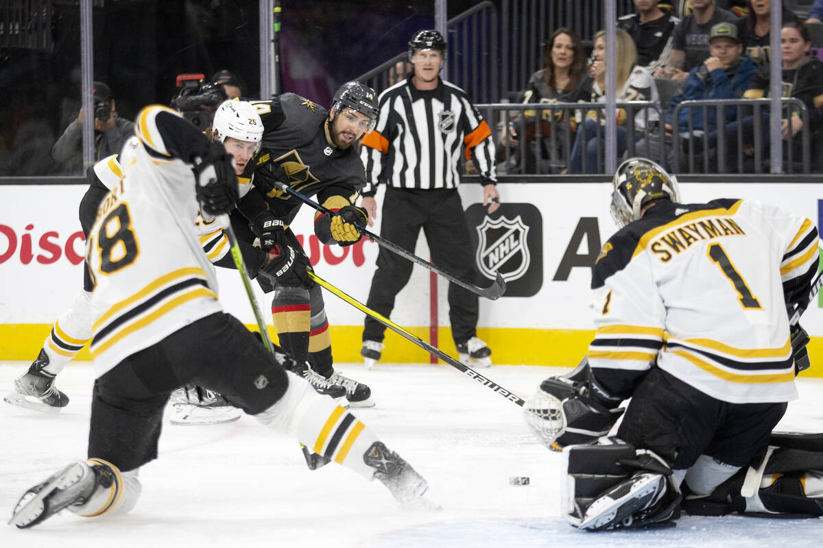 Golden Knights defenseman Nicolas Hague (14) takes a shot on Bruins goaltender Jeremy Swayman ( ...