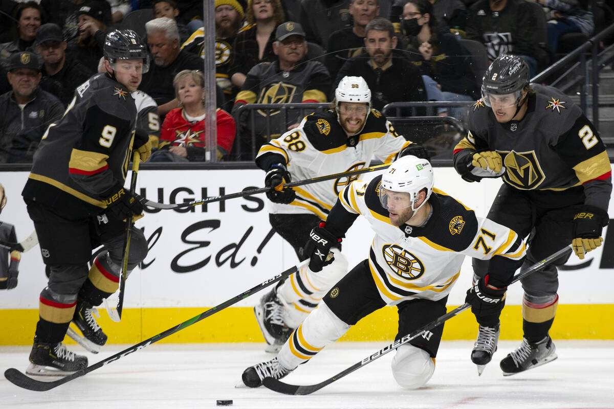 Bruins left wing Taylor Hall (71) dives for the puck followed by Golden Knights center Jack Eic ...