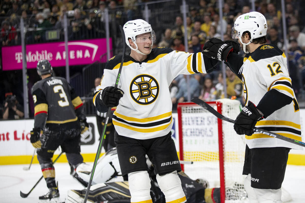 Bruins center Trent Frederic (11) and center Craig Smith (12) celebrate after Smith scored a go ...