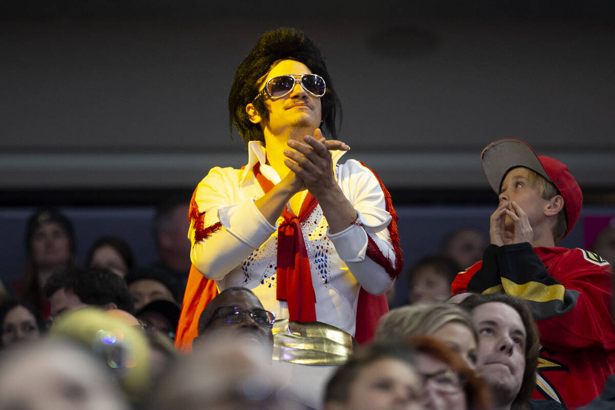 A Golden Knights fan wears an Elvis costume during the third period of an NHL hockey game again ...