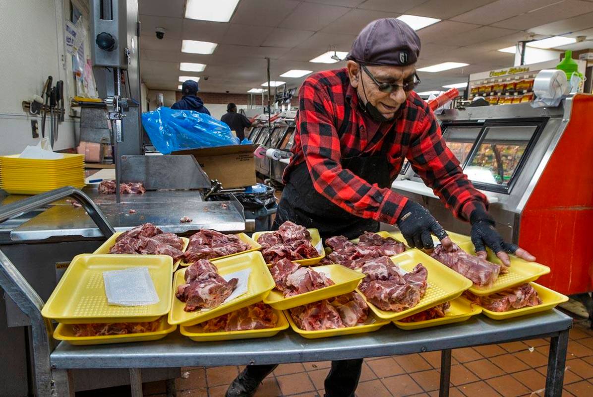 Tony Haber cuts up fresh pork for their meat counter at Mario's Westside Market looking for a m ...