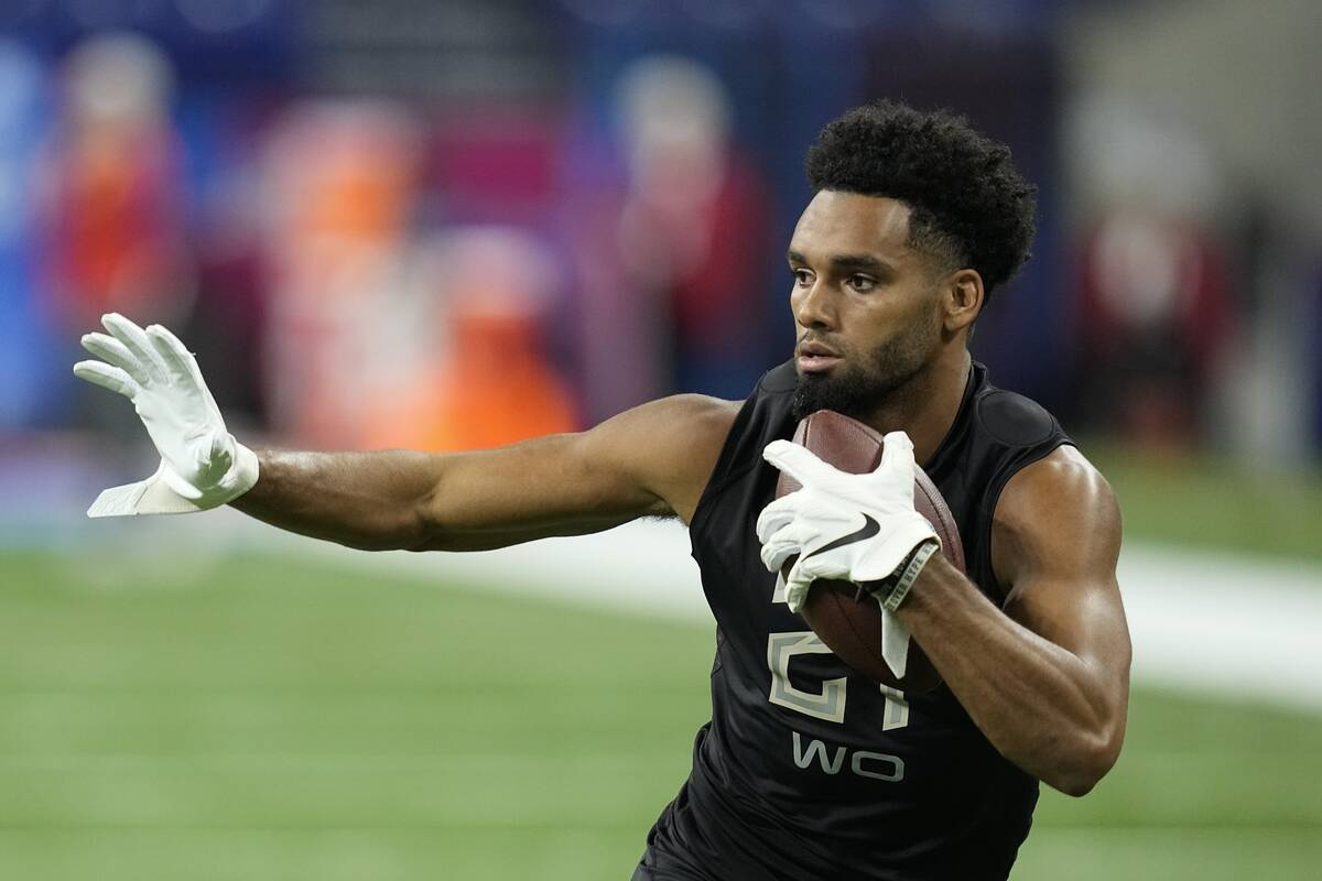 Ohio State wide receiver Chris Olave runs a drill during the NFL football scouting combine, Thu ...