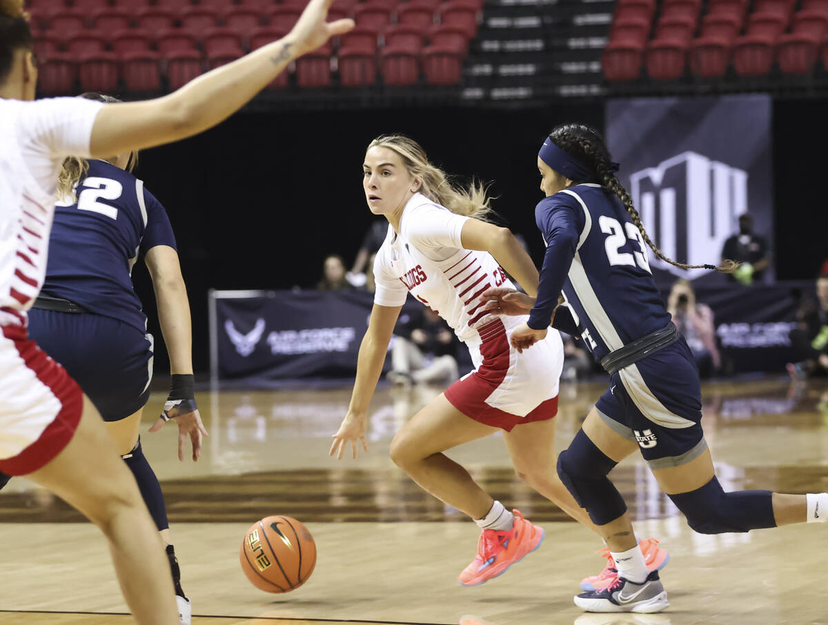 Fresno State Bulldogs guard Hanna Cavinder (0) drives the ball against Utah State Aggies guard ...