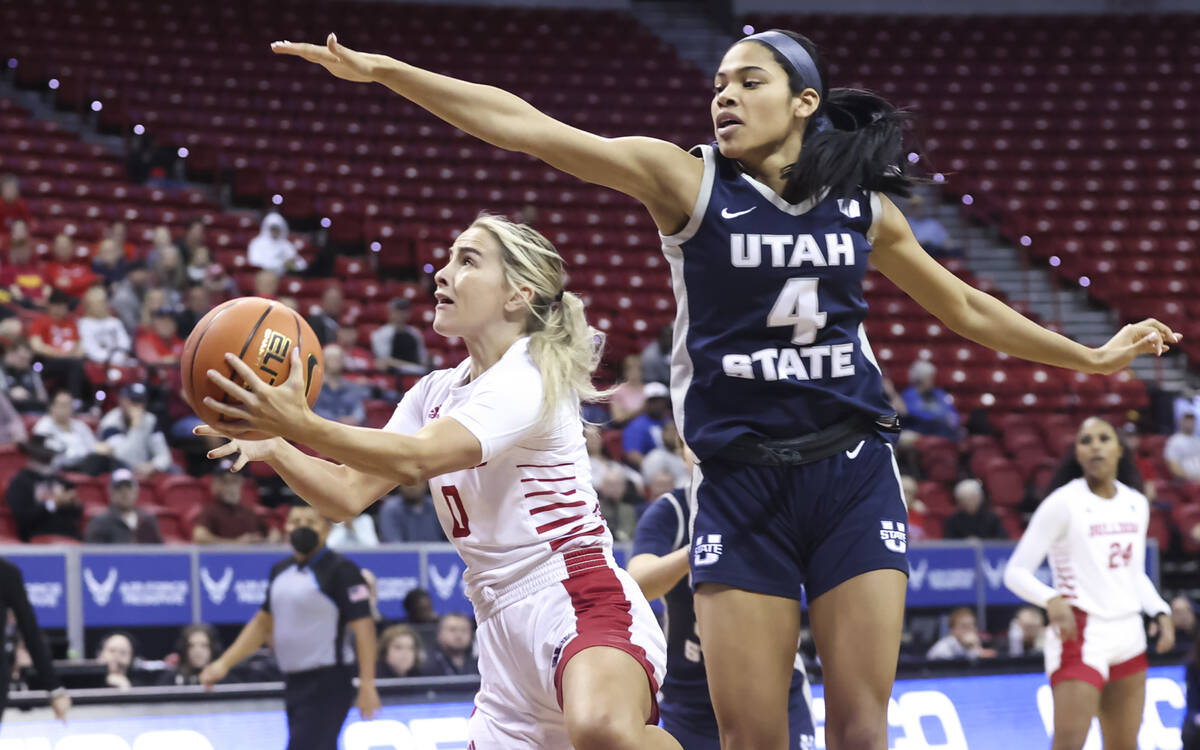 Fresno State Bulldogs guard Hanna Cavinder (0) shoots under pressure from Utah State Aggies gua ...