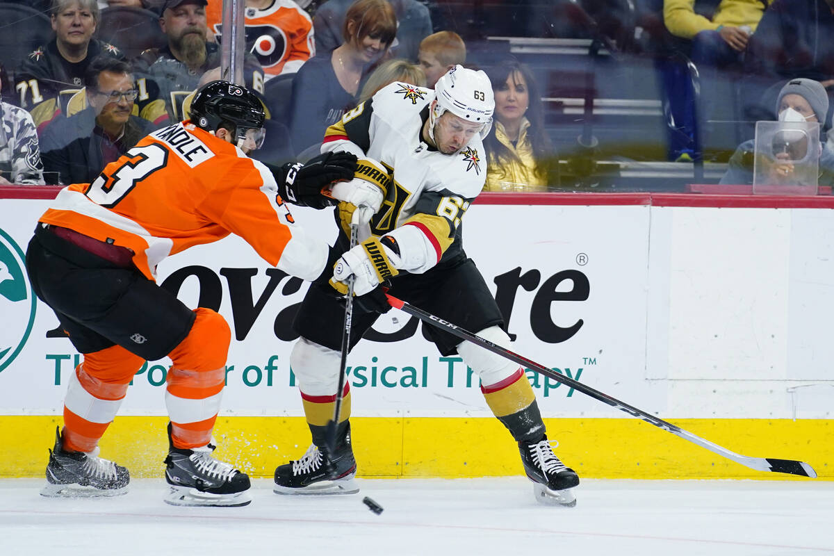 Vegas Golden Knights' Evgenii Dadonov, right, shoots the puck against Philadelphia Flyers' Keit ...