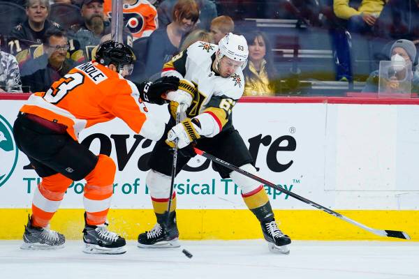 Vegas Golden Knights' Evgenii Dadonov, right, shoots the puck against Philadelphia Flyers' Keit ...
