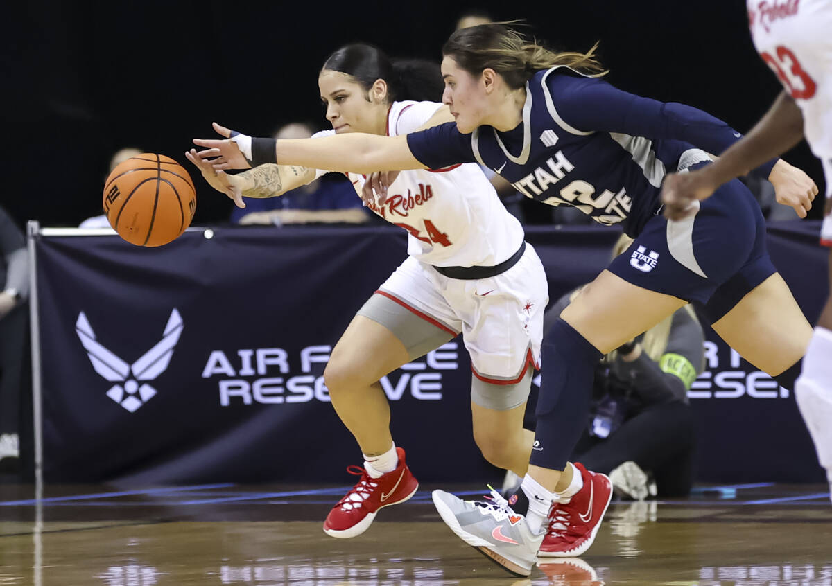 UNLV Lady Rebels guard Essence Booker (24) and Utah State Aggies guard Adryana Quezada (32) bat ...