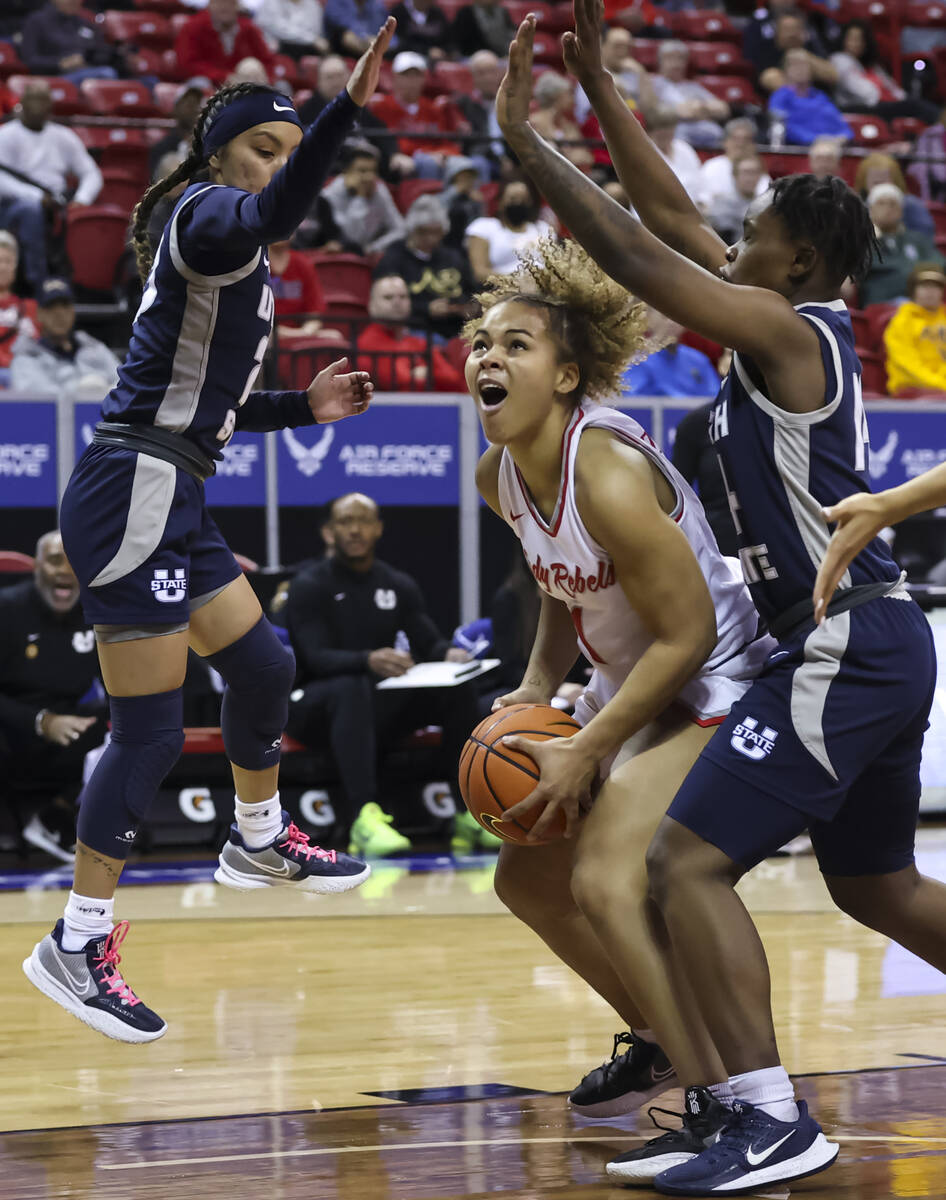 UNLV Lady Rebels forward Nneka Obiazor (1) looks to shoot as Utah State Aggies guards Shyla Lat ...