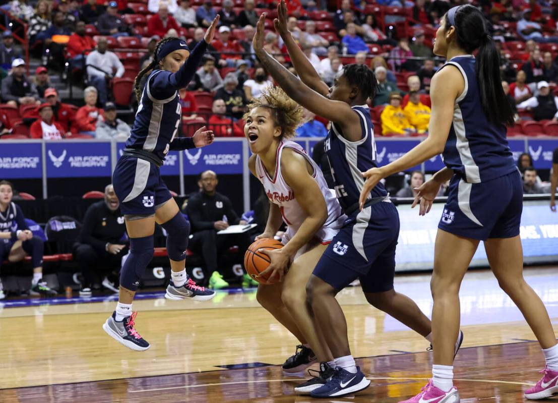 UNLV Lady Rebels forward Nneka Obiazor (1) looks to shoot as Utah State Aggies guards Shyla Lat ...