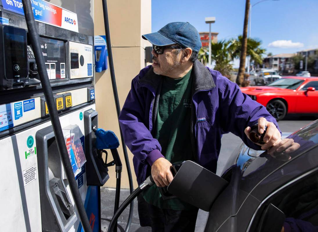 Ken Yamaguchi of Las Vegas pumps gas at Arco on Charleston Boulevard on Monday, March 7, 2022, ...