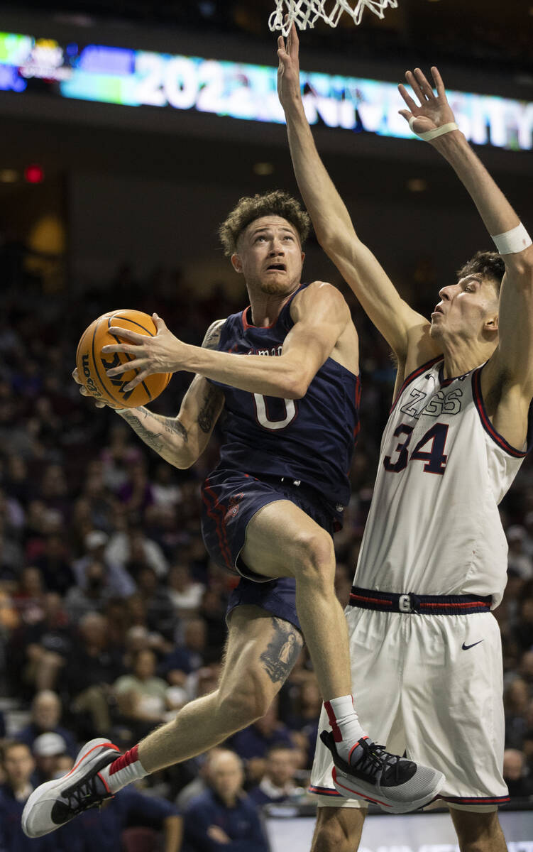 St. Mary's Gaels guard Logan Johnson (0) slices to the rim past Gonzaga Bulldogs center Chet Ho ...