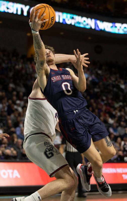 St. Mary's Gaels guard Logan Johnson (0) slices to the rim past Gonzaga Bulldogs center Chet Ho ...