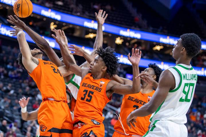 Oregon State Beavers forward Isaiah Johnson (24) battles for a rebound with Oregon Ducks center ...