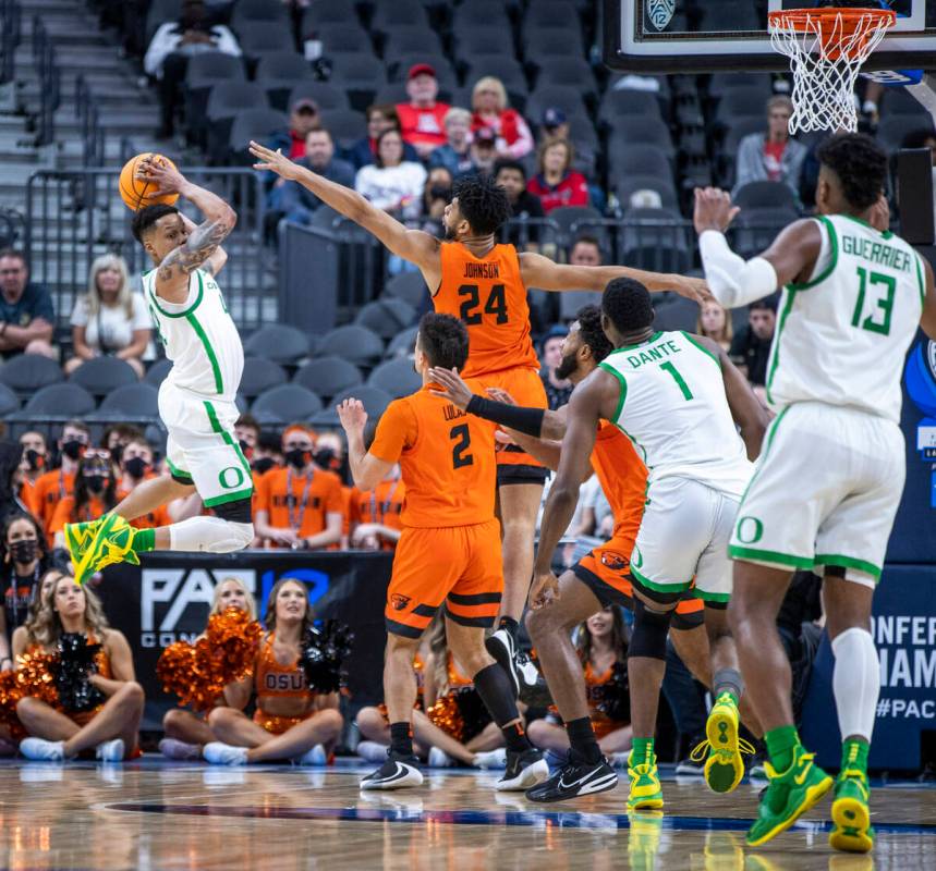 Oregon Ducks guard Jacob Young (42) looks to pass from the air defended by Oregon State Beavers ...