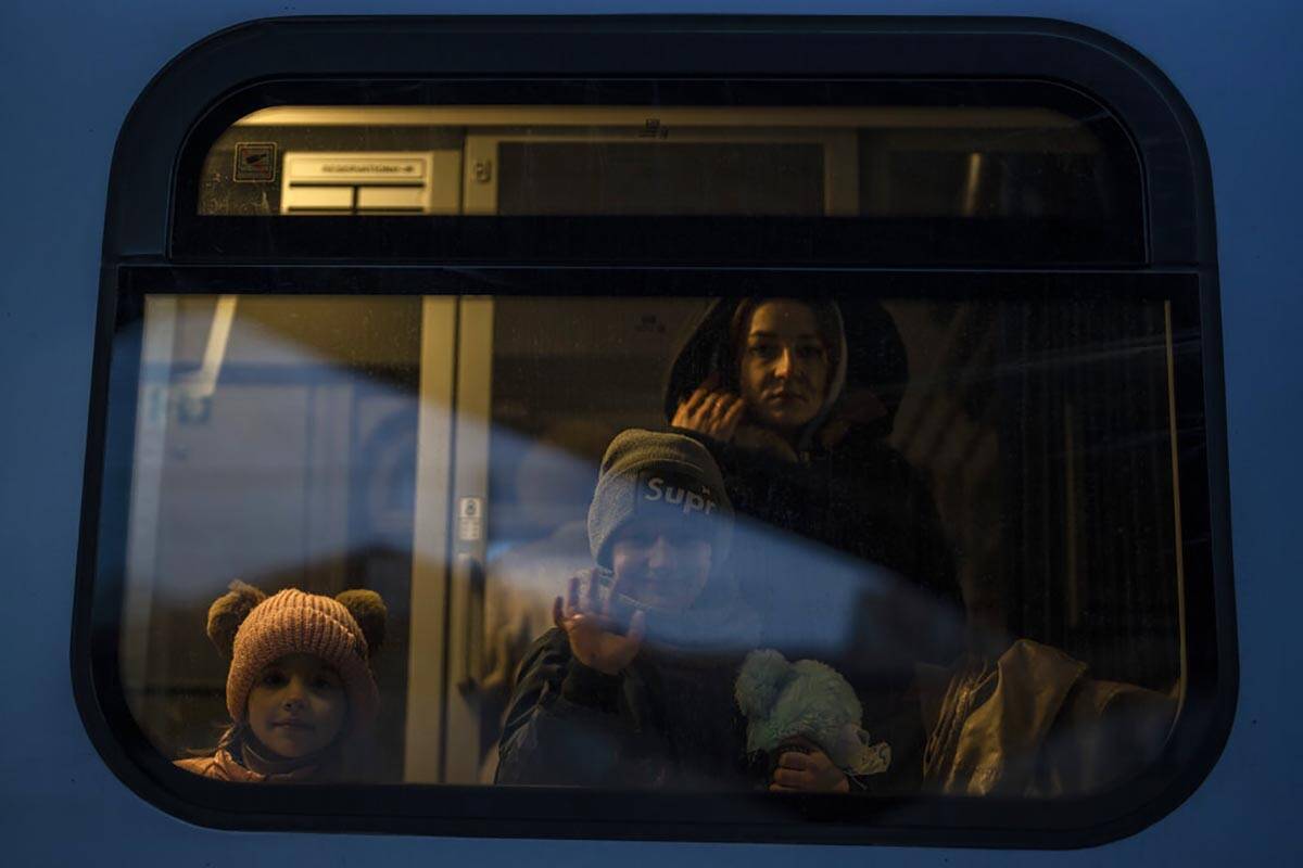 A boy who fled the war from neighbouring Ukraine waves as he looks out with other refugees from ...