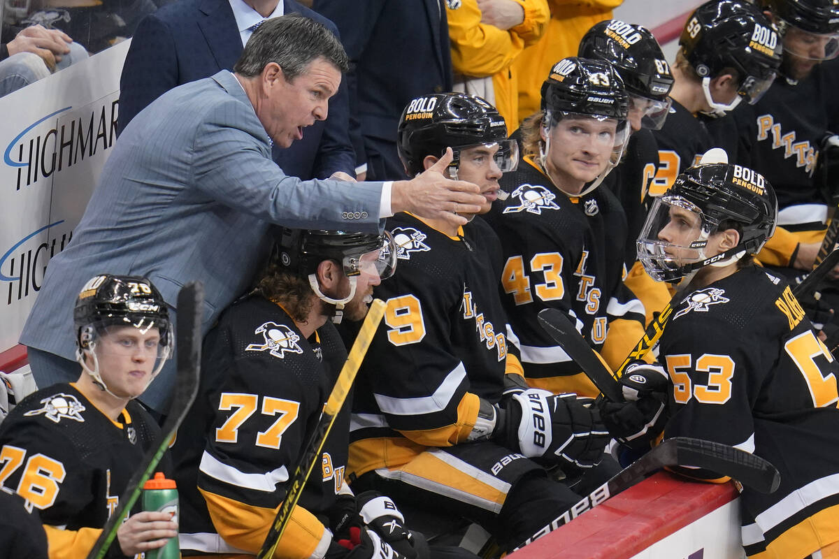 Pittsburgh Penguins coach Mike Sullivan, left, gives instructions to Teddy Blueger (53) during ...